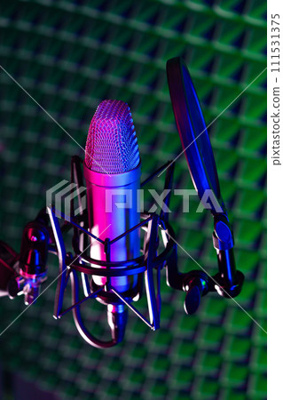 Professional studio microphone against acoustic foam panel background in neon light 111531375