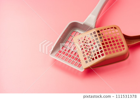 Plastic pet scoop on pink background close up Plastic pet scoop on pink background close up 111531378
