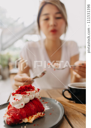 Cake being eat by woman in the cafe. Focus selective on the cake. Cake being eat by woman in the cafe. Focus selective on the cake. 111531396
