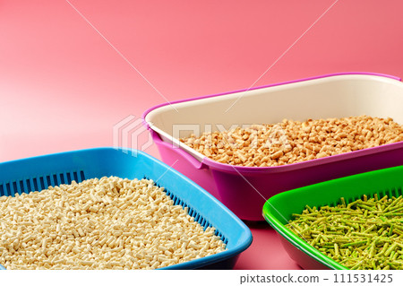 Pet litter box with bio filler on pink background 111531425