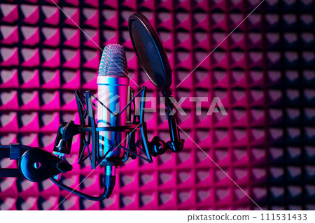 Professional studio microphone against acoustic foam panel background in neon light Professional studio microphone against acoustic foam panel background in neon light 111531433