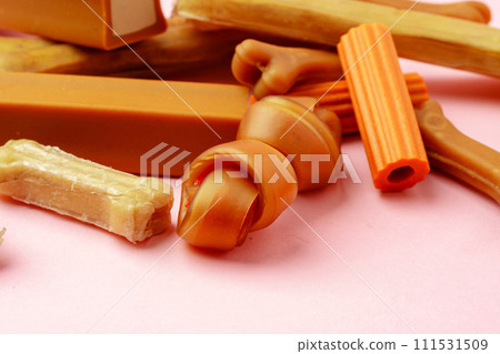 Dog chew bone and sticks on pink background Dog chew bone and sticks on pink background 111531509