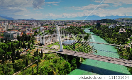 Aerial view of the cityscape of Podgorica behind the Millennium Bridge, a cable-stayed bridge over the Moracha. Montenegro 111531694