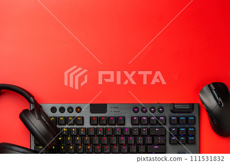 Computer keyboard and headphones on red background top view Computer keyboard and headphones on red background top view 111531832
