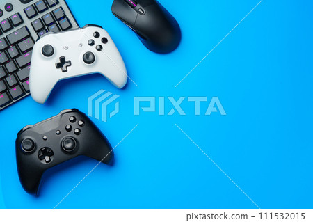Computer keyboard and joystick on blue background top view Computer keyboard and joystick on blue background top view 111532015