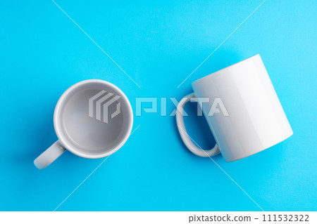 Two ceramic mugs on blue studio background 111532322