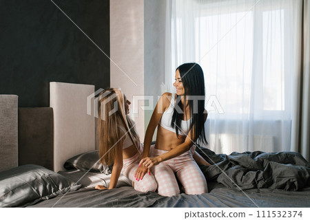 Mom and baby on the bed communicate, have fun and laugh. Family, love and laughter in the morning at home 111532374