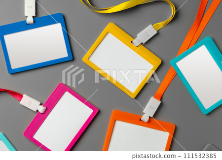 Colored blank nametags on strings on gray background Colored blank nametags on strings on gray background 111532385