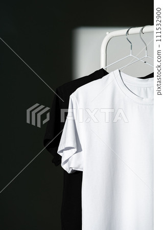 Blank T-shirt hanging in a spotlight in studio 111532900