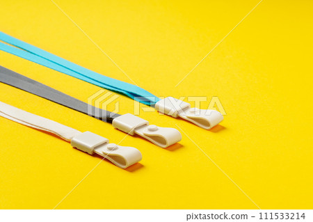 Badge strings on yellow background close up 111533214