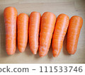 Carrots lined up in a row on the table 111533746