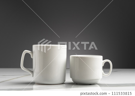 Ceramic cups on marble table against gray background Ceramic cups on marble table against gray background 111533815
