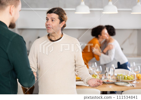 In home, male friends shake hands, say goodbye after socializing and gatherings. 111534841