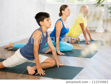 Group of people perform pigeon asana 111534861