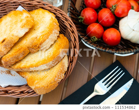Kitchen table with cooking tools and fresh vegetables. Pan Con tomate, bread with tomato and garlic. Catalonian cuisine. Spain Kitchen table with cooking tools and fresh vegetables. Pan Con tomate, bread with tomato and garlic. Catalonian cuisine. Spain 111534862