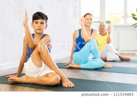 Mother, grandmother and adolescence son do exercise lord of fish, Ardha Matsyedrasana 111534865