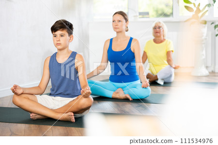 Group of people generation on mats doing yoga exercise lord of fishes pose. Group of people generation on mats doing yoga exercise lord of fishes pose. 111534976