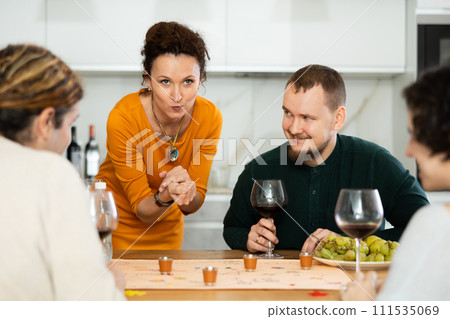 Group of friends is playing board game. 111535069