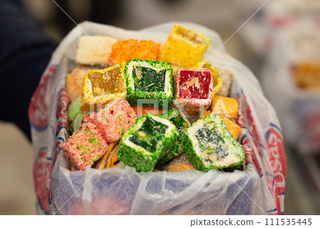 Traditional oriental sweets - Rahat Lukum. Fruit candy with fruit fillings. Different colors and different sprinkles. 111535445