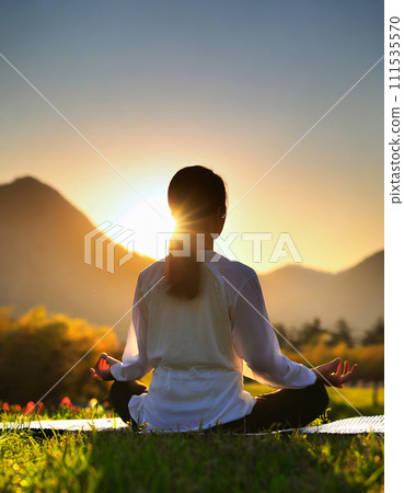 黎明時分，一名女子以瑜珈姿勢冥想的 AI 圖像 111535570