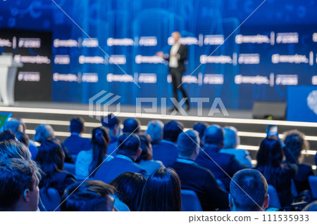 Professional speaker at corporate conference presenting to audience Professional speaker at corporate conference presenting to audience 111535933