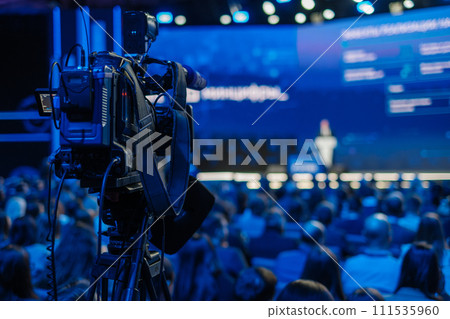 Professional video camera recording speaker at business conference event 111535960