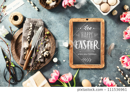 Happy Easter text on vintage chalk board, spring flowers and cutlery 111536961