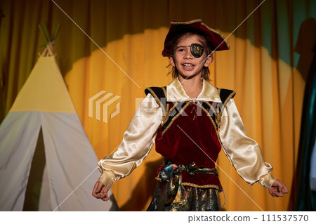 Waist up portrait of young boy wearing pirate costume performing on stage in school play Waist up portrait of young boy wearing pirate costume performing on stage in school play 111537570
