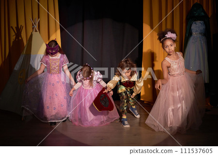 Full length portrait of group of children taking final bow on stage in school play production 111537605