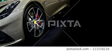 Front view of headlights modern sport car on black background, free space on right side for text Front view of headlights modern sport car on black background, free space on right side for text 111538216