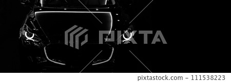 Front view silhouette of black modern car with headlights on black background. Front view silhouette of black modern car with headlights on black background. 111538223