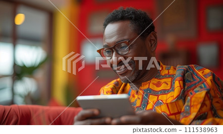 AI-generated content. On a red studio background, a smiling African man browses the internet on a tablet, networks on the internet, and scrolls on an app. Finished email and typing. 111538963