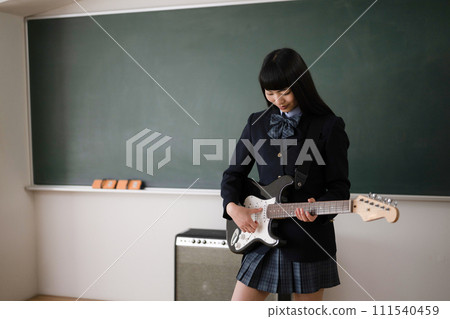 Student playing the guitar, image of a brass band or light music club activity 111540459