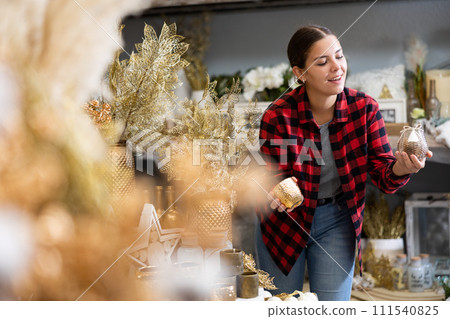 Positive woman chooses Christmas gifts in gift shop 111540825