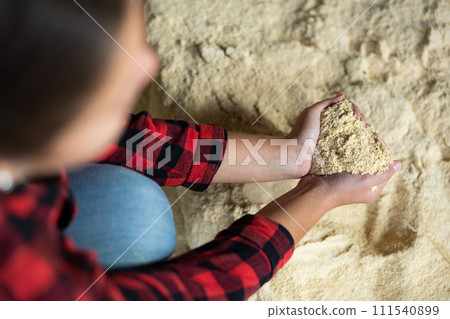 Woman farmer holding pile of corn flour 111540899