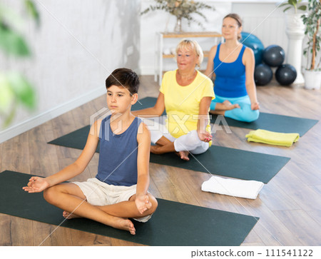 Family three generations do half lotus position Sidhasana with hands clasped in mudra of knowledge Family three generations do half lotus position Sidhasana with hands clasped in mudra of knowledge 111541122