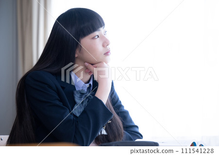 High school girl looking up and thinking by the classroom window, copy space available 111541228