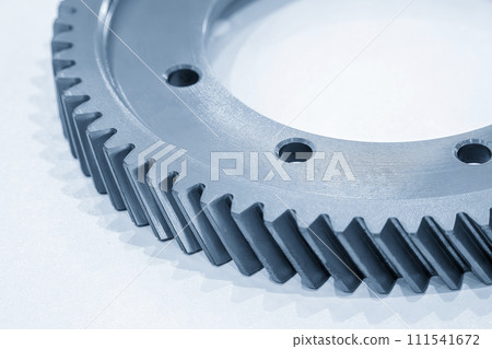 Close up scene the helical gear parts spare parts in the light blue scene. Close up scene the helical gear parts spare parts in the light blue scene. 111541672