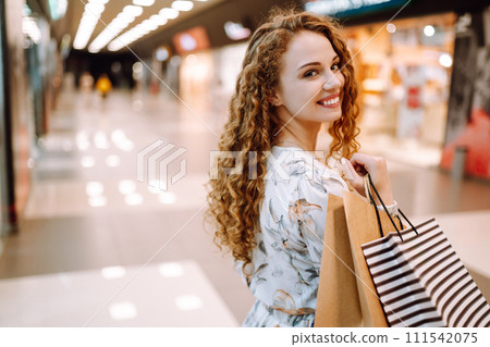 Fashionable woman with multi-colored bags in modern shop center. The joy of consumption. 111542075