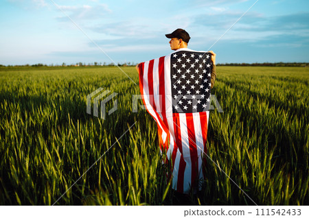 Man hold waving american USA flag. Patriot raise national american flag. Independence Day, 4th July. 111542433