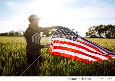 Man hold waving american USA flag. Patriot raise national american flag. Independence Day, 4th July. 111542436