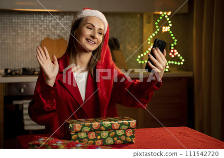 Young Woman in Santa Hat Making a Video Call During Christmas Celebration at Home 111542720