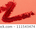 Red lipstick stroke on a red background close-up macro 111543474