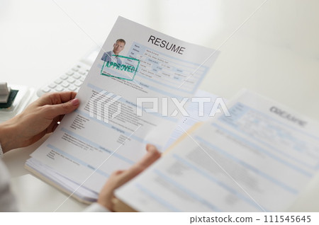 Women's hands hold a resume of a man, close-up 111545645