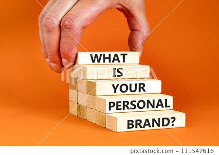 What is your personal brand symbol. Concept words What is your personal brand on wooden blocks. Beautiful orange background. Businessman hand. Business, what is your personal brand concept. Copy space 111547616