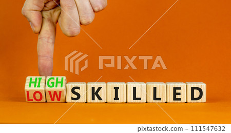 High or low skilled symbol. Concept words High skilled or Low skilled on beautiful wooden blocks. Beautiful orange background. Businessman hand. Business high or low skilled concept. Copy space. 111547632