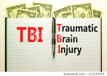 TBI traumatic brain injury symbol. Concept words TBI traumatic brain injury on white note on a beautiful background from dollar bills. Pen. Medical and TBI traumatic brain injury concept. Copy space TBI traumatic brain injury symbol. Concept words TBI traumatic brain injury on white note on a beautiful background from dollar bills. Pen. Medical and TBI traumatic brain injury concept. Copy space 111547674