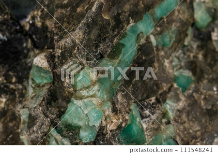 Macro emerald stone mineral in rock on white background Macro emerald stone mineral in rock on white background 111548241