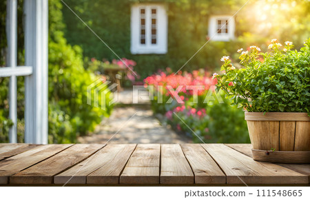 An empty wooden table in the foreground, with a blurred country house in the background against a verdant garden setting An empty wooden table in the foreground, with a blurred country house in the background against a verdant garden setting 111548665