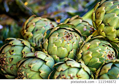 Bunch of green artichokes sitting on top of each other 111548872